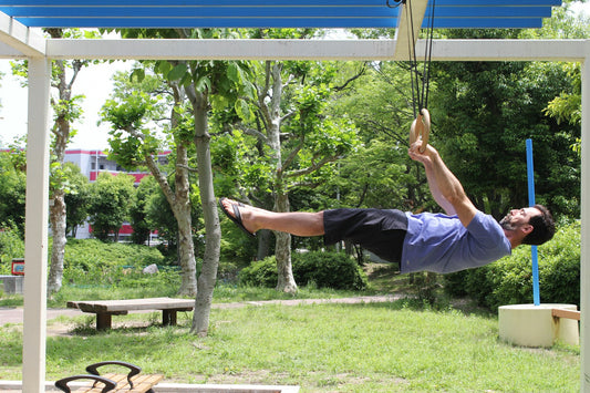 Athlete holding a horizontal lever on gymnastic rings outdoors