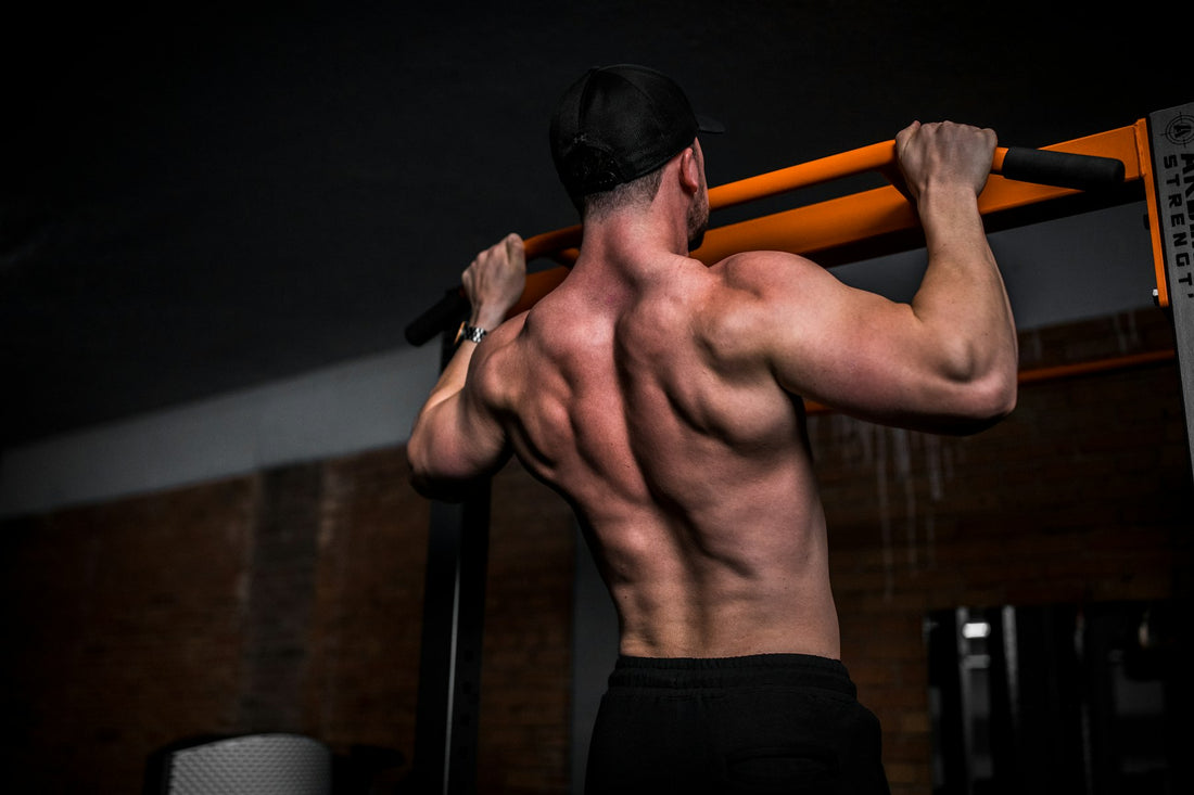 Athlete doing a pull-up on a bar, seen from behind
